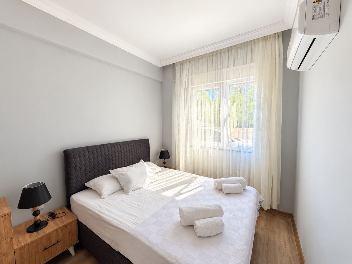 Bedroom with a double bed, fresh towels and a bedside lamp