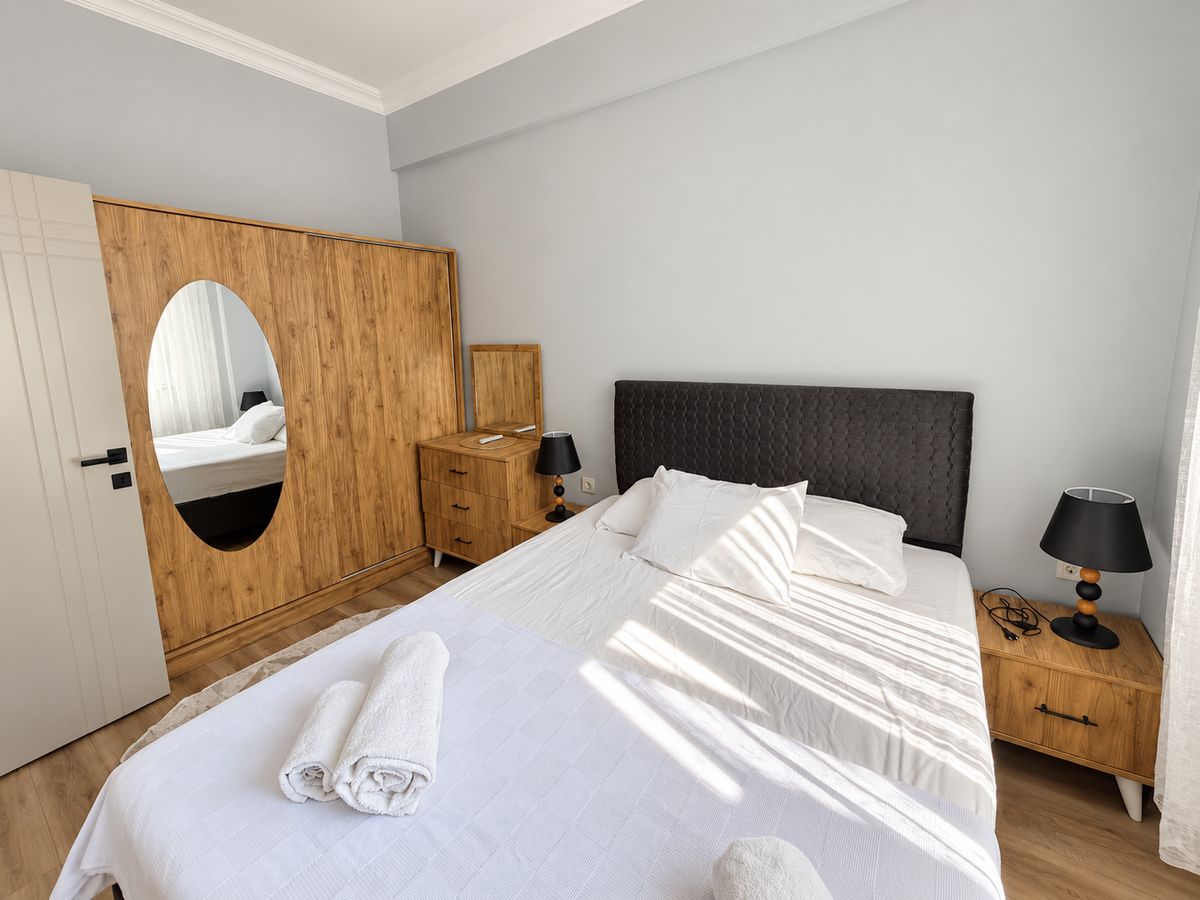 Bright bedroom with a wardrobe mirror and a double bed
